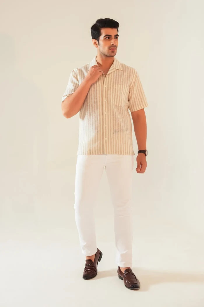 Full front view of beige striped oversized shirt with camp collar styled with white trousers