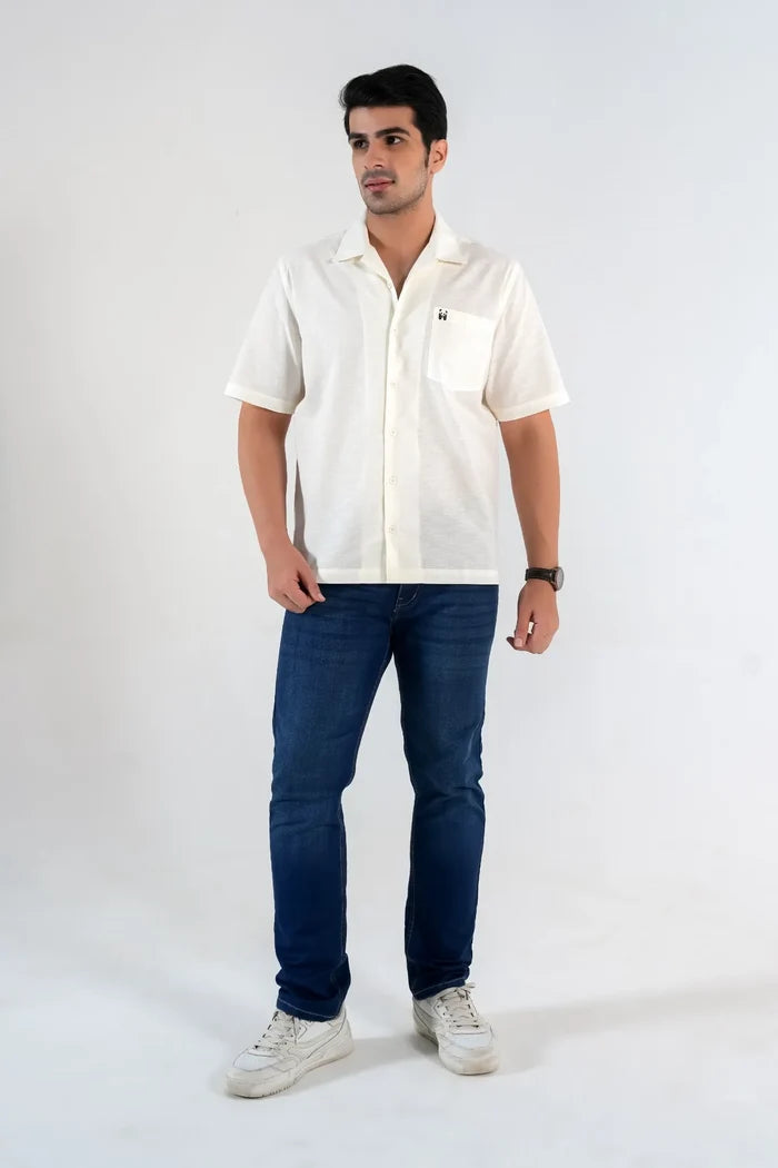 Model wearing off-white linen blend oversized shirt with blue jeans on white background