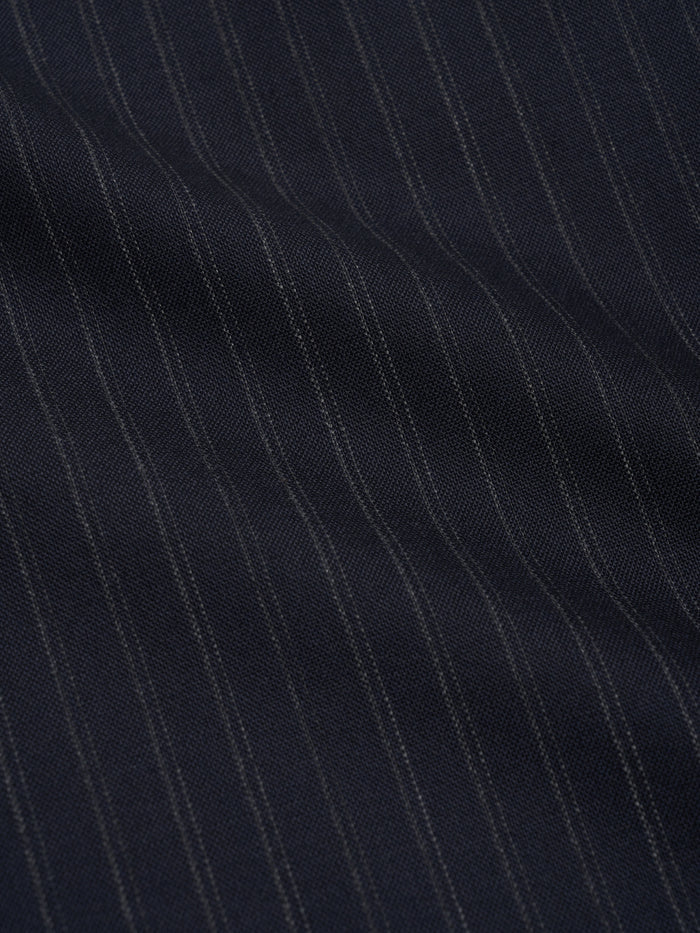 Orsman wide-leg navy pinstripe wool trousers worn on model, fabric close up view