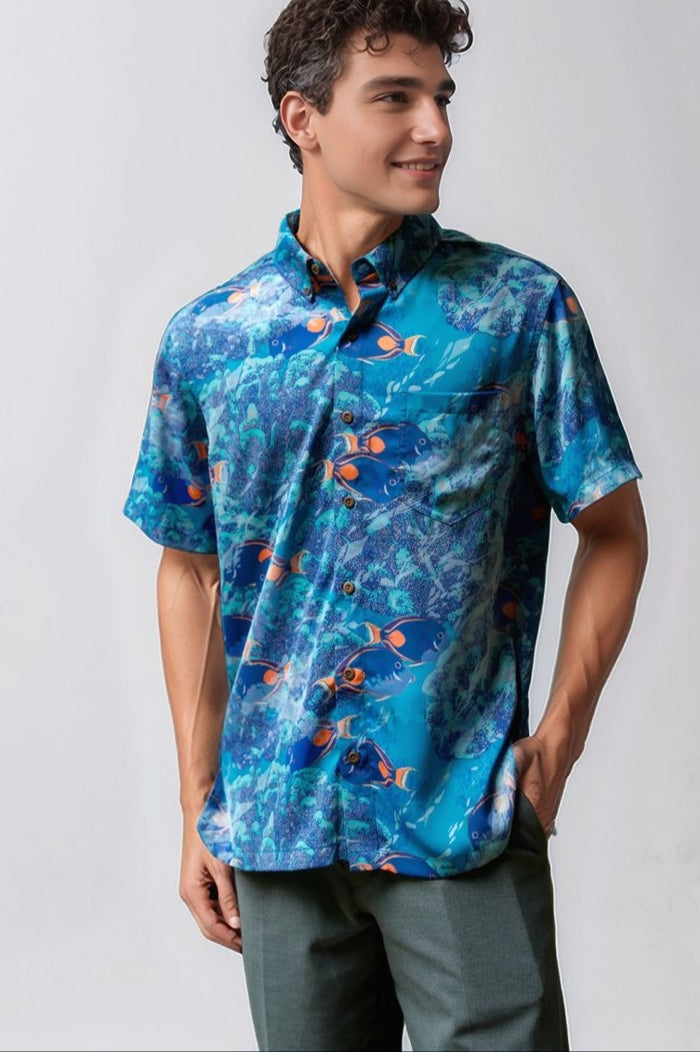Man wearing a blue David Shepard patterned aloha shirt against a white background