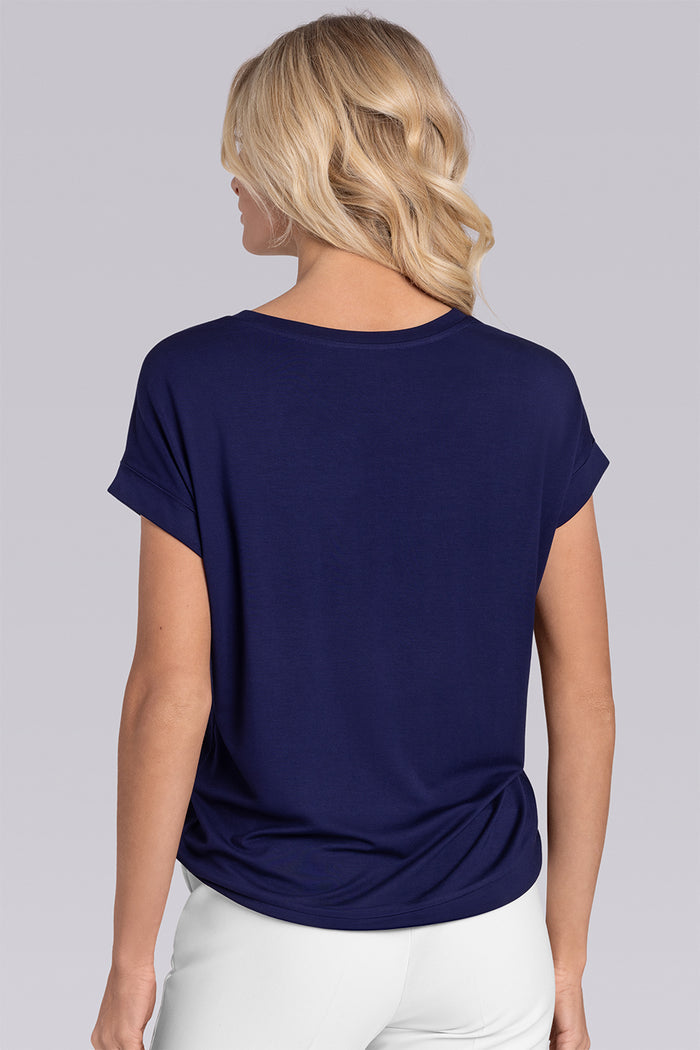 Model wearing Savanna Deep Sea Blue Icy Bamboo® crew neck short sleeve t-shirt, styled with white pants.