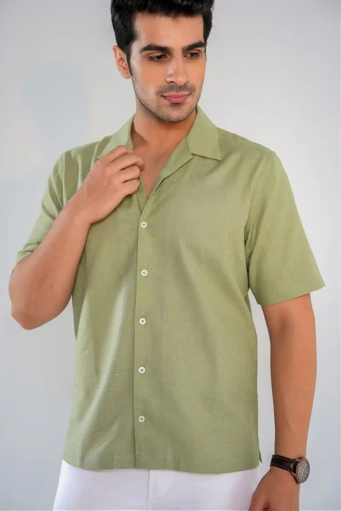Man wearing a green short-sleeve shirt against a plain background