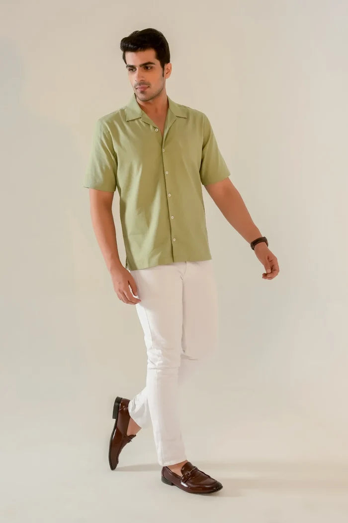 Man walking in seafoam green Cuban collar shirt styled with white chinos and brown loafers