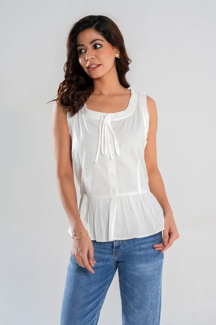 Woman wearing white sleeveless cotton cottagecore peplum top with round neckline, frill detail and button-up front – Drape Panda